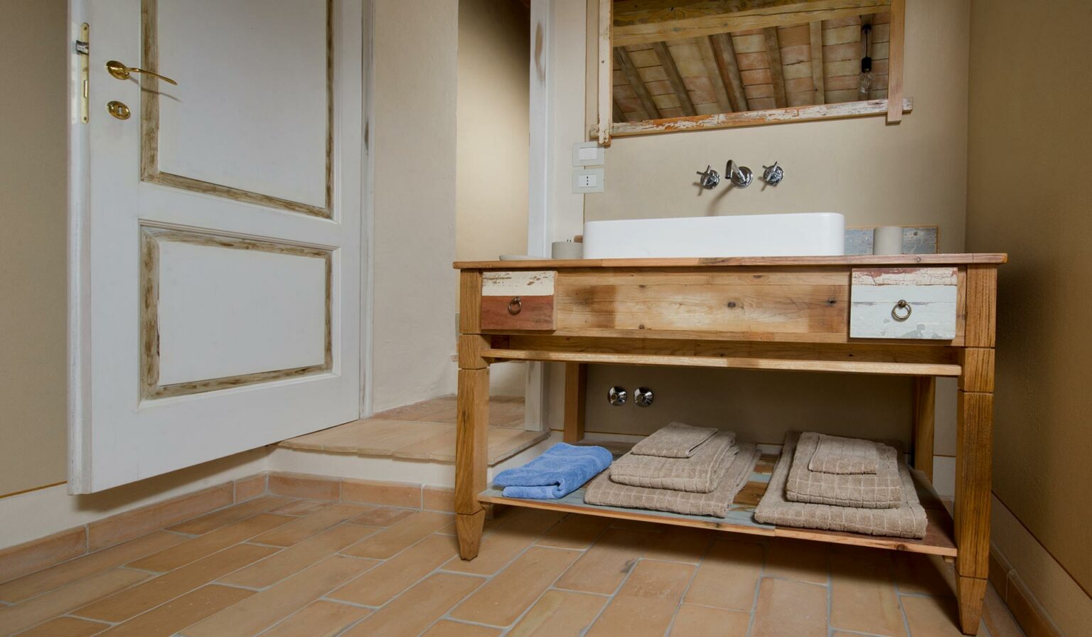 mobiletto bagno legno di recupero per un casale in Toscana con pavimento in cotto antico e pietra